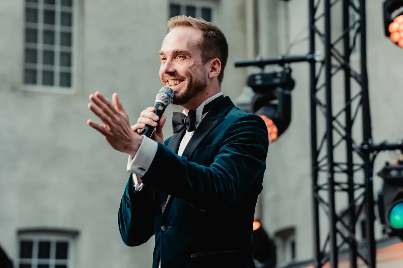 Business host Felix Uhlig with a microphone at the Speira gala