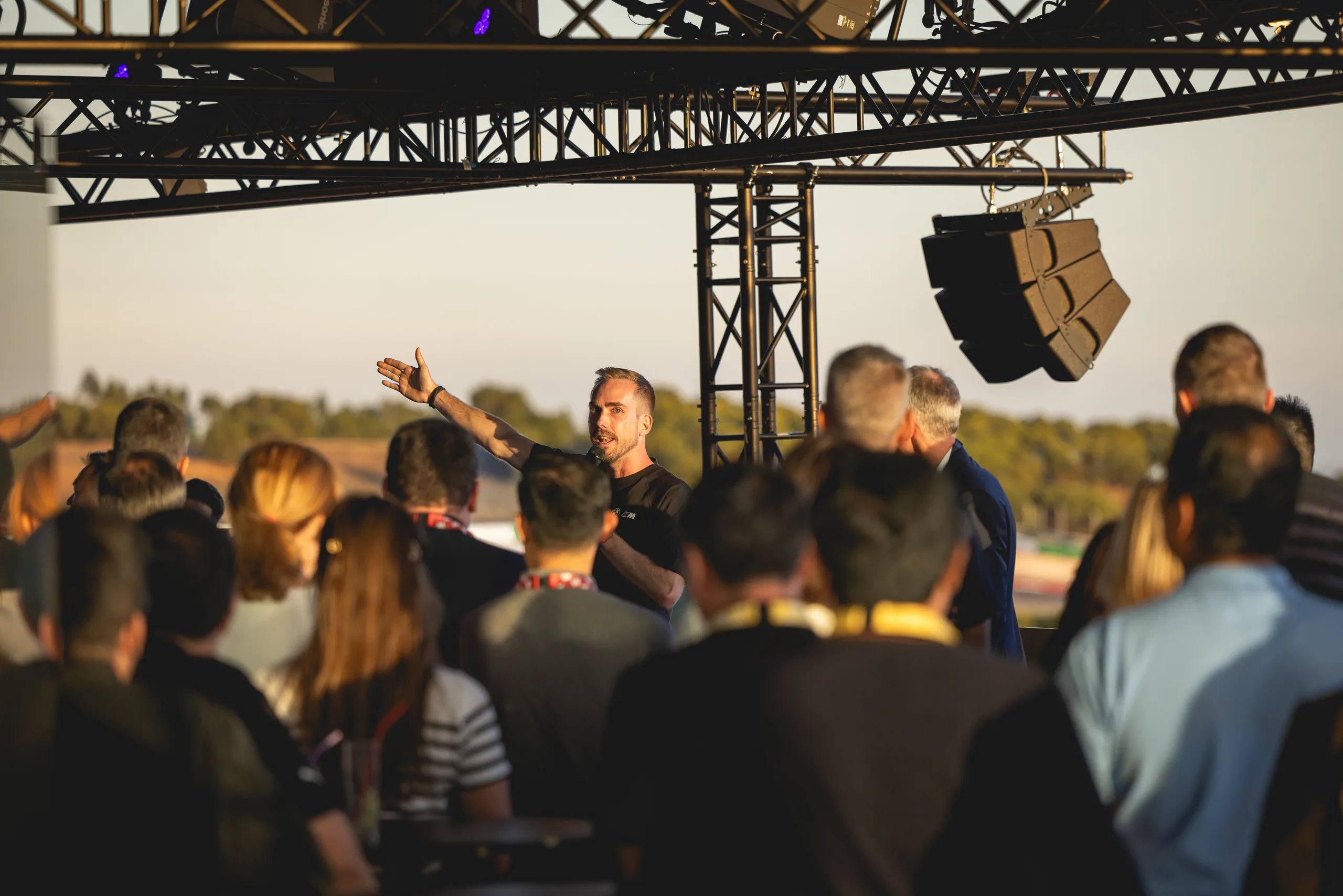 Moderator Felix Uhlig mit ausgebreiteten Armen beim Abendprogramm der BMW M Experience Conference am Algarve International Circuit
