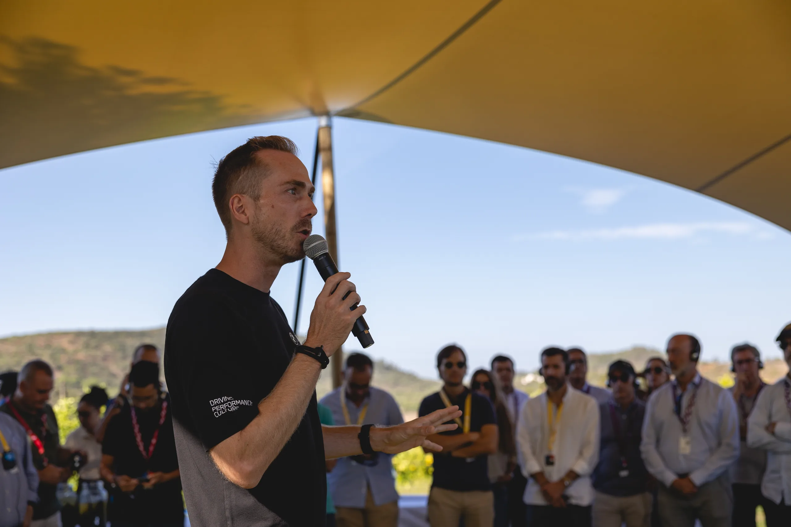 Moderator Felix Uhlig mit Mikrofon vor den Gästen der BMW M Experience Conference in Portugal