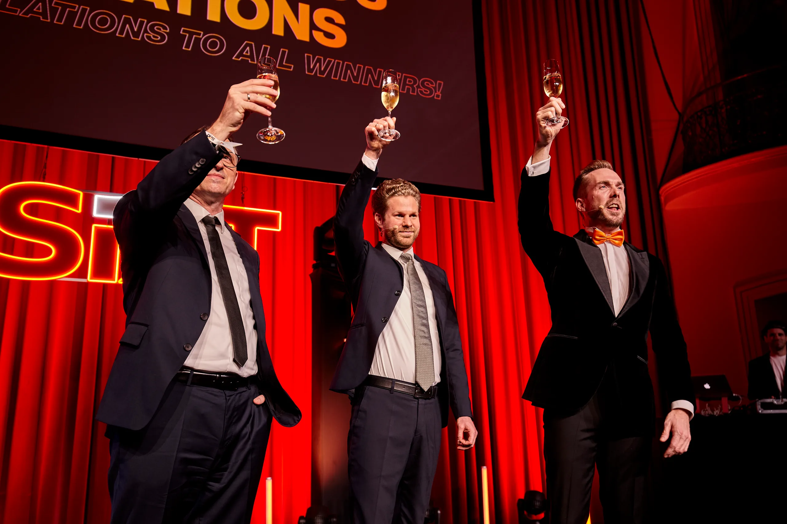 Felix Uhlig stößt mit zwei Preisträgern auf der Bühne der SIXT World Conference 2024 in Wien an