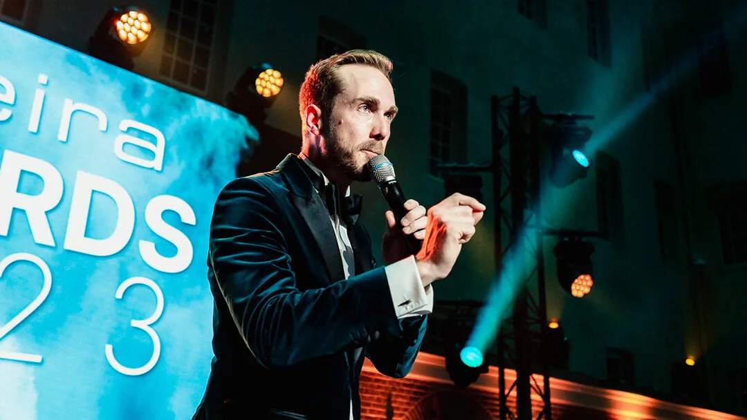 Felix Uhlig hosting the Speira Inspeiration Summit 2023 in Amsterdam, stage screen behind him