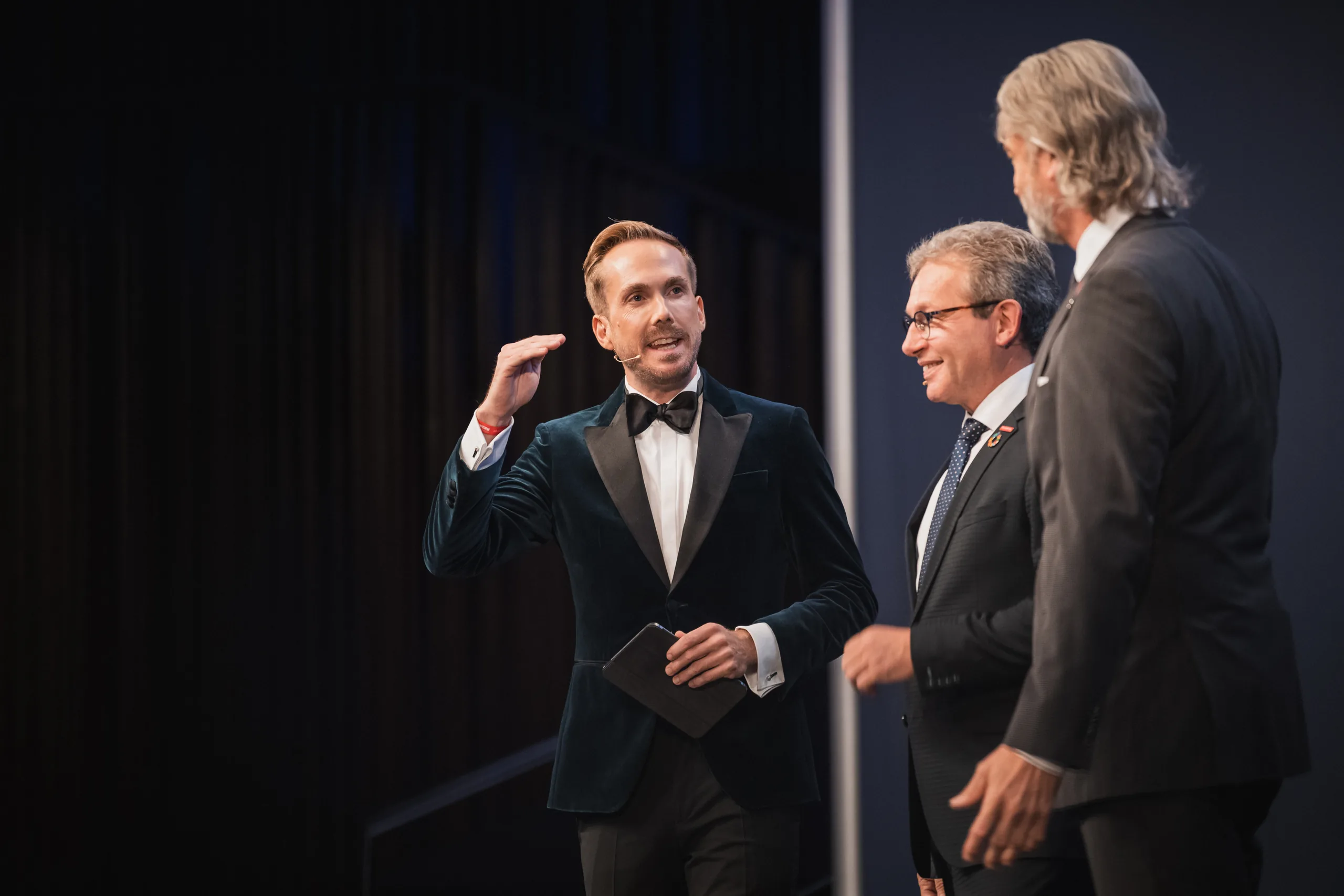 Felix Uhlig im Gespräch mit zwei Gästen auf der Bühne der Meister- und Meisterinnenfeier der Handwerkskammer Hannover 2024