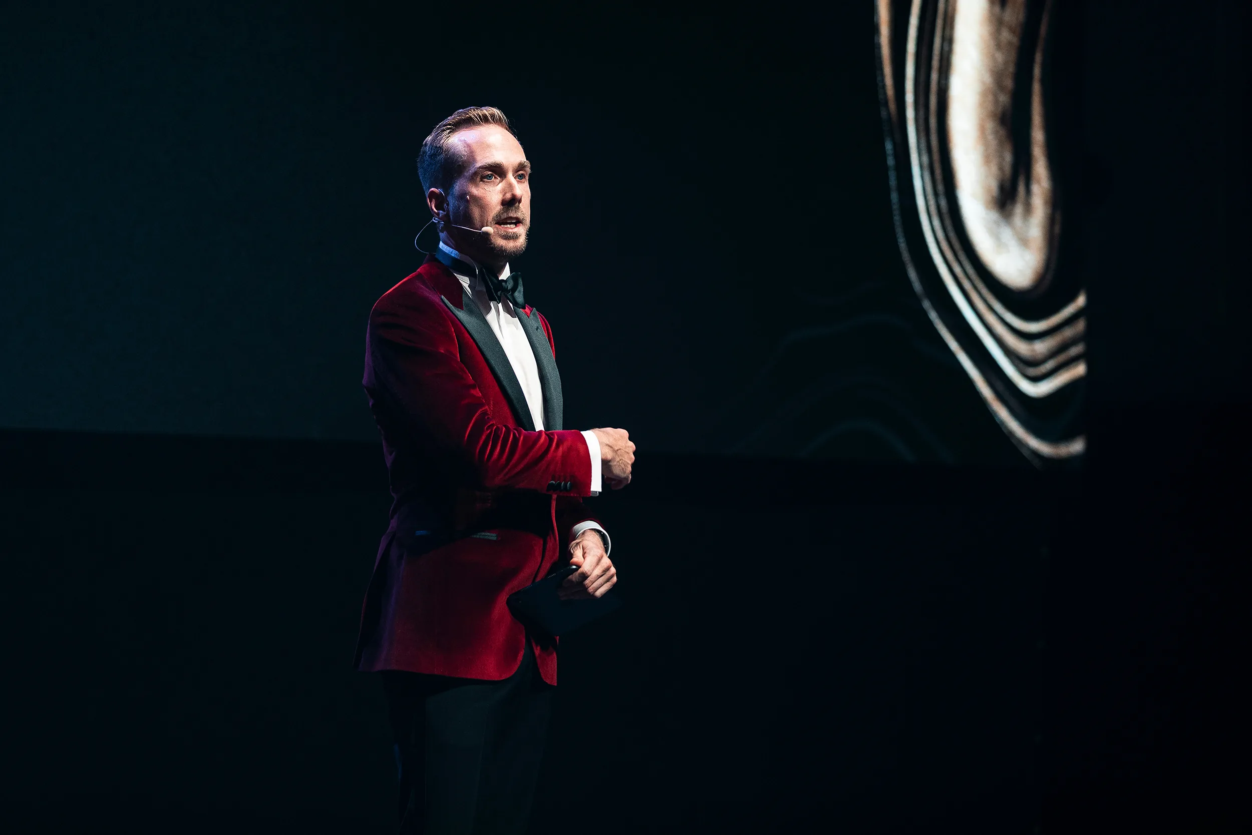 Moderator Felix Uhlig im roten Samtsakko beim Reunion Banquet der Midea MBT Partner Conference 2023 in Budapest