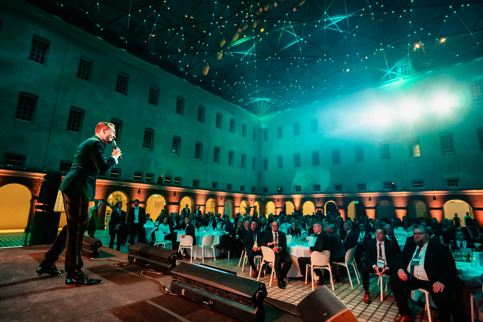 Der beleuchtete Innenhof des Schifffahrtsmuseums Amsterdam beim Speira Inspeiration Summit 2023, Felix Uhlig auf der Bühne
