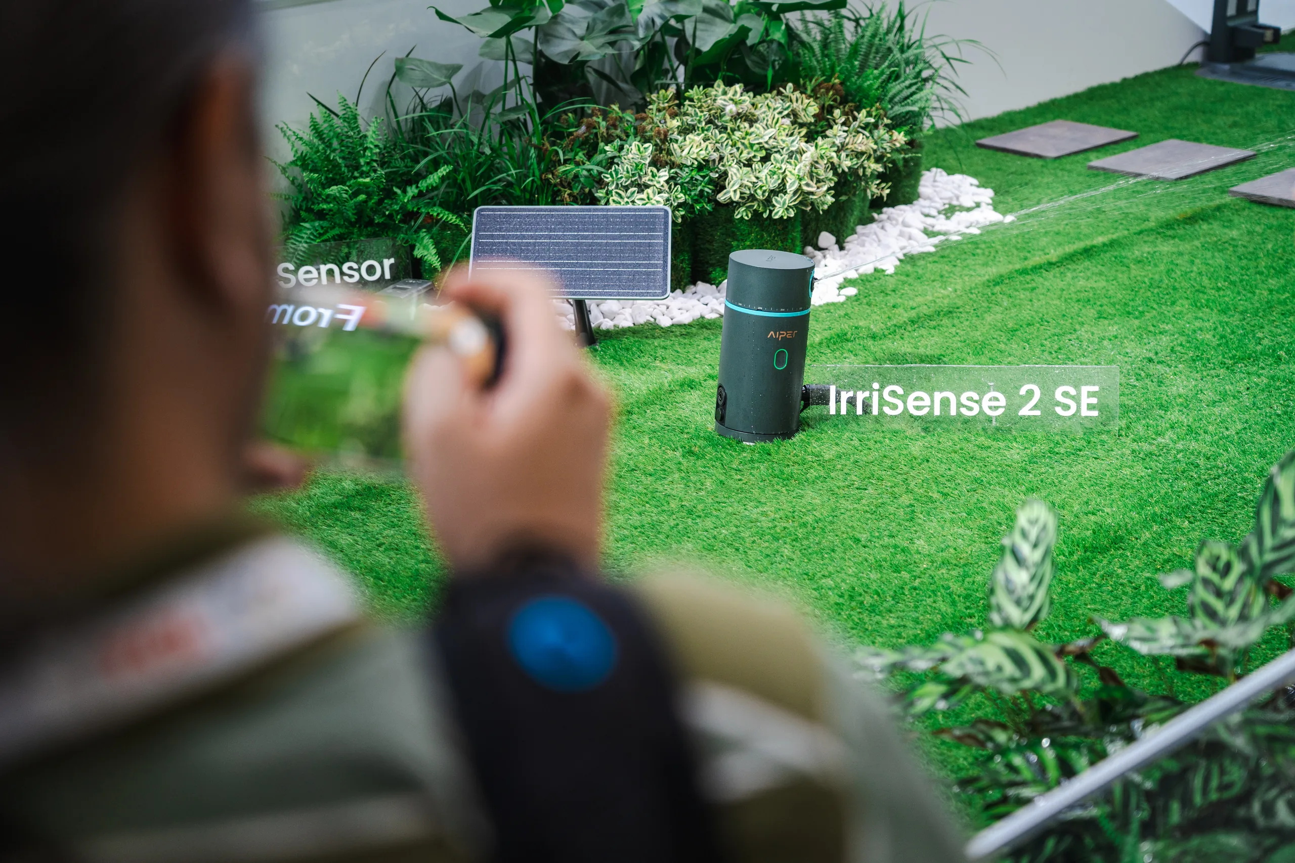 Der Rasensprenger Aiper IrriSense 2 SE im angelegten Garten des Messestands auf der IFA 2026 in Berlin