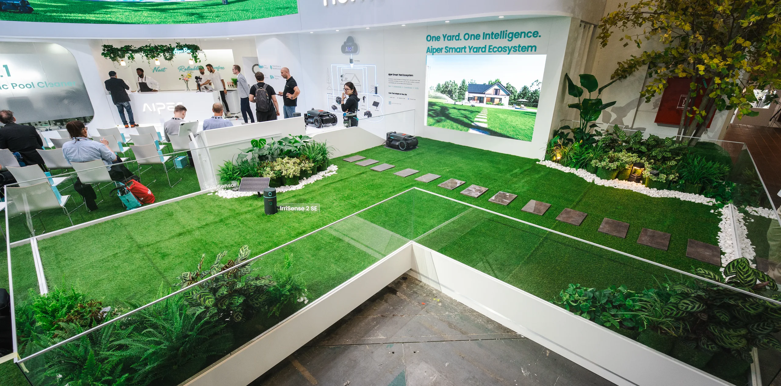 Der Aiper-Messestand auf der IFA 2026 in Berlin mit angelegtem Garten und dem Claim One Yard. One Intelligence.