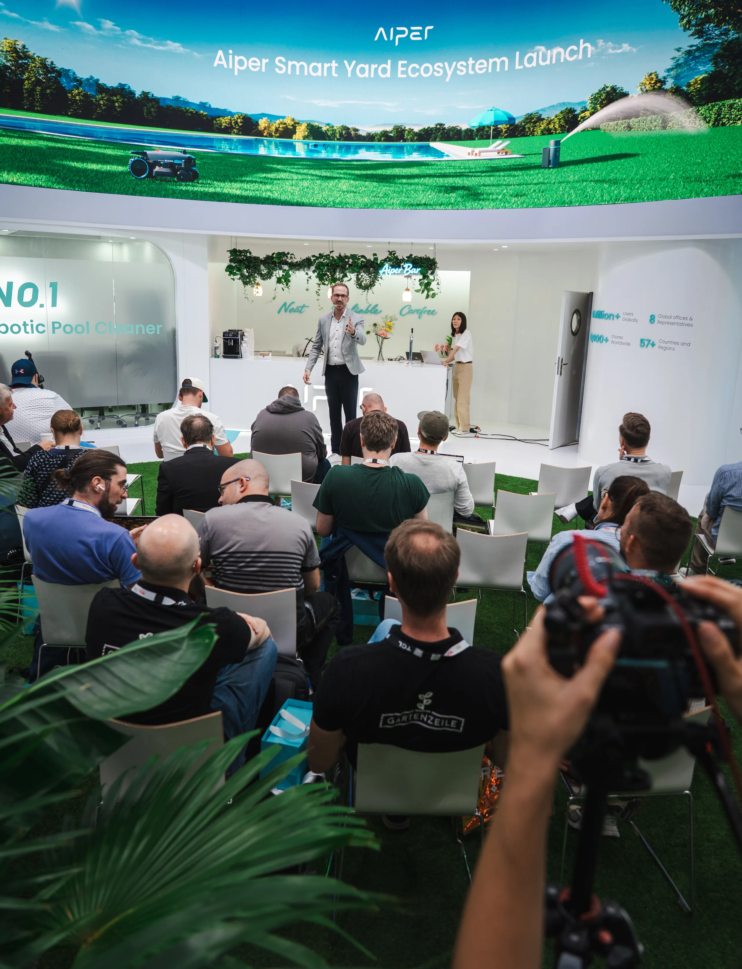 Moderator Felix Uhlig auf der Bühne vor der LED-Wand mit dem Schriftzug Aiper Smart Yard Ecosystem Launch, davor das Publikum der Pressekonferenz