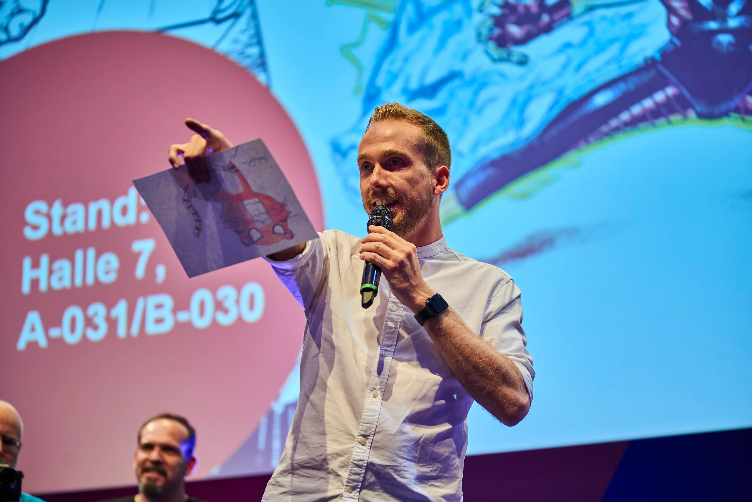 Felix Uhlig am Mikrofon vor der Faber-Castell-Leinwand auf der CCXP 2019 in Köln