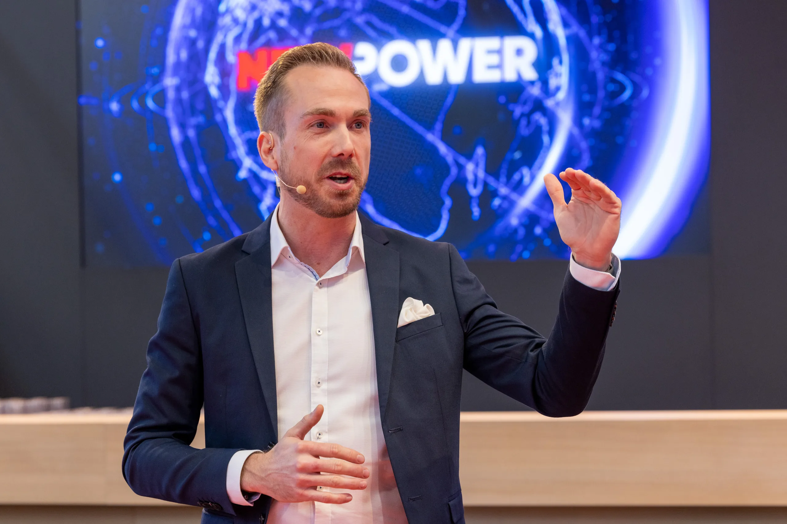 Felix Uhlig moderiert vor der NewPower-Videowand bei der Electronica 2022 in München