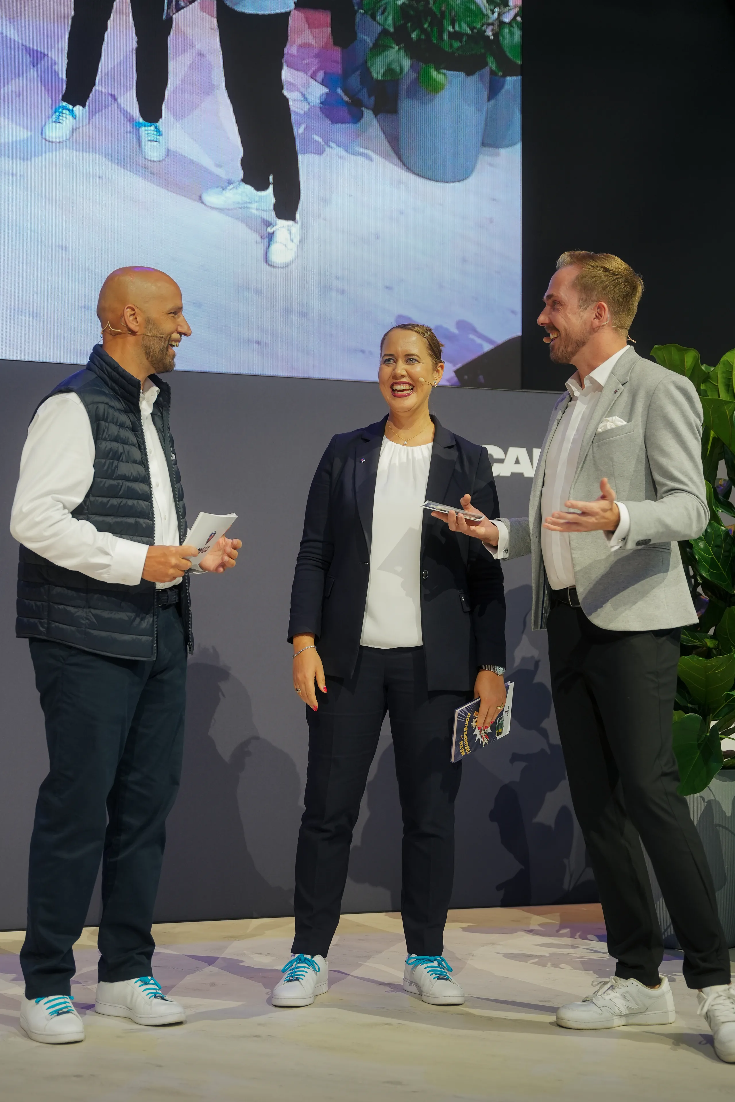 Felix Uhlig moderiert ein Podiumsgespräch zu dritt am Scania-Stand der IAA Transportation