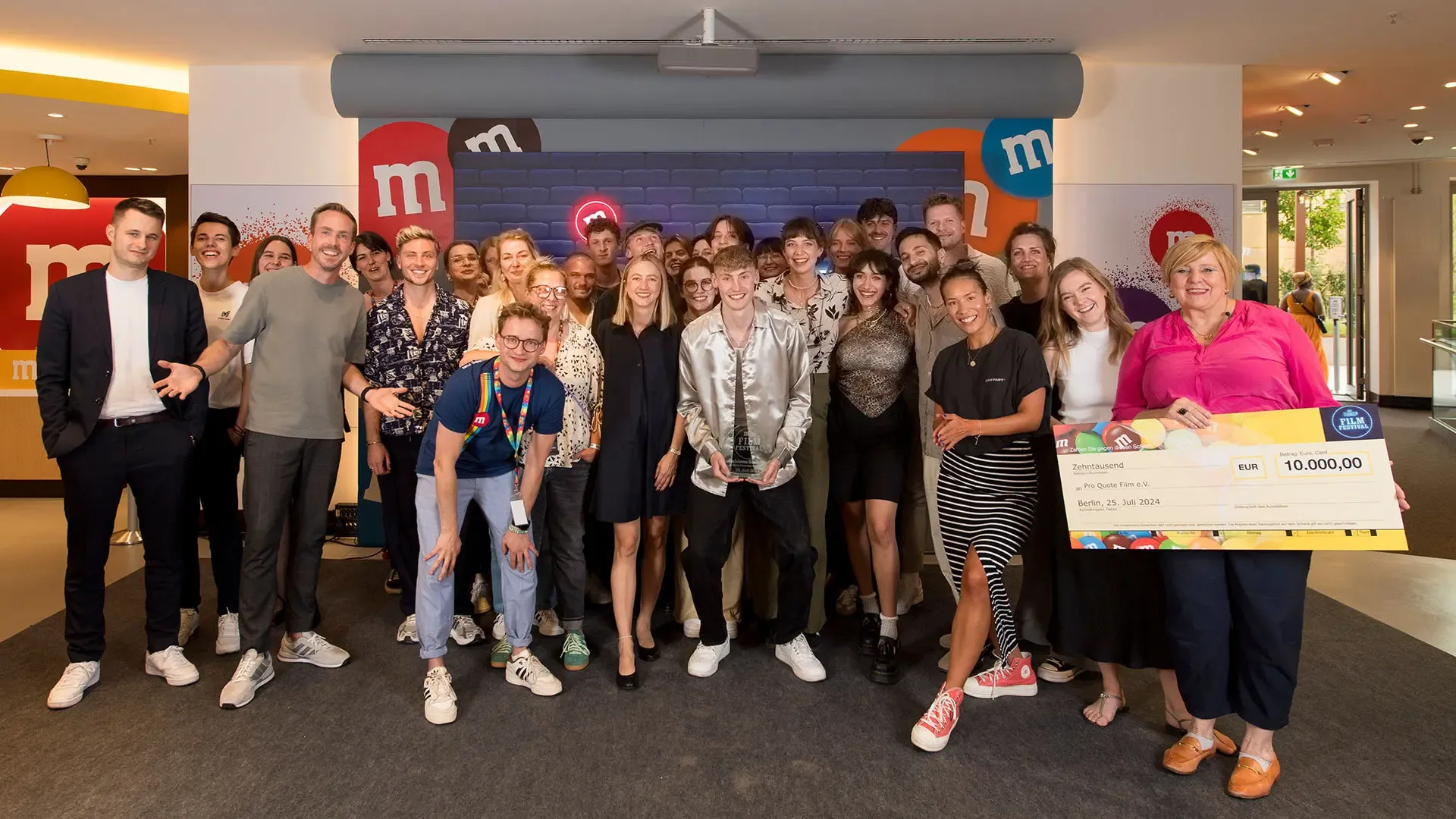 Group photo at the end of the M&M's Short Film Festival 2024 with host Felix Uhlig, the nominees and the winning team in Berlin