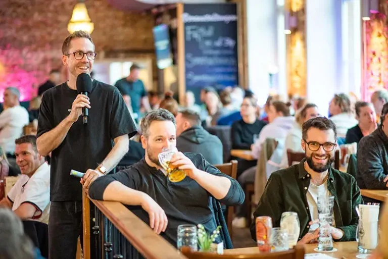 Felix Uhlig moderiert ein Bezzer-Quizzer-Pubquiz vor vollen Tischen