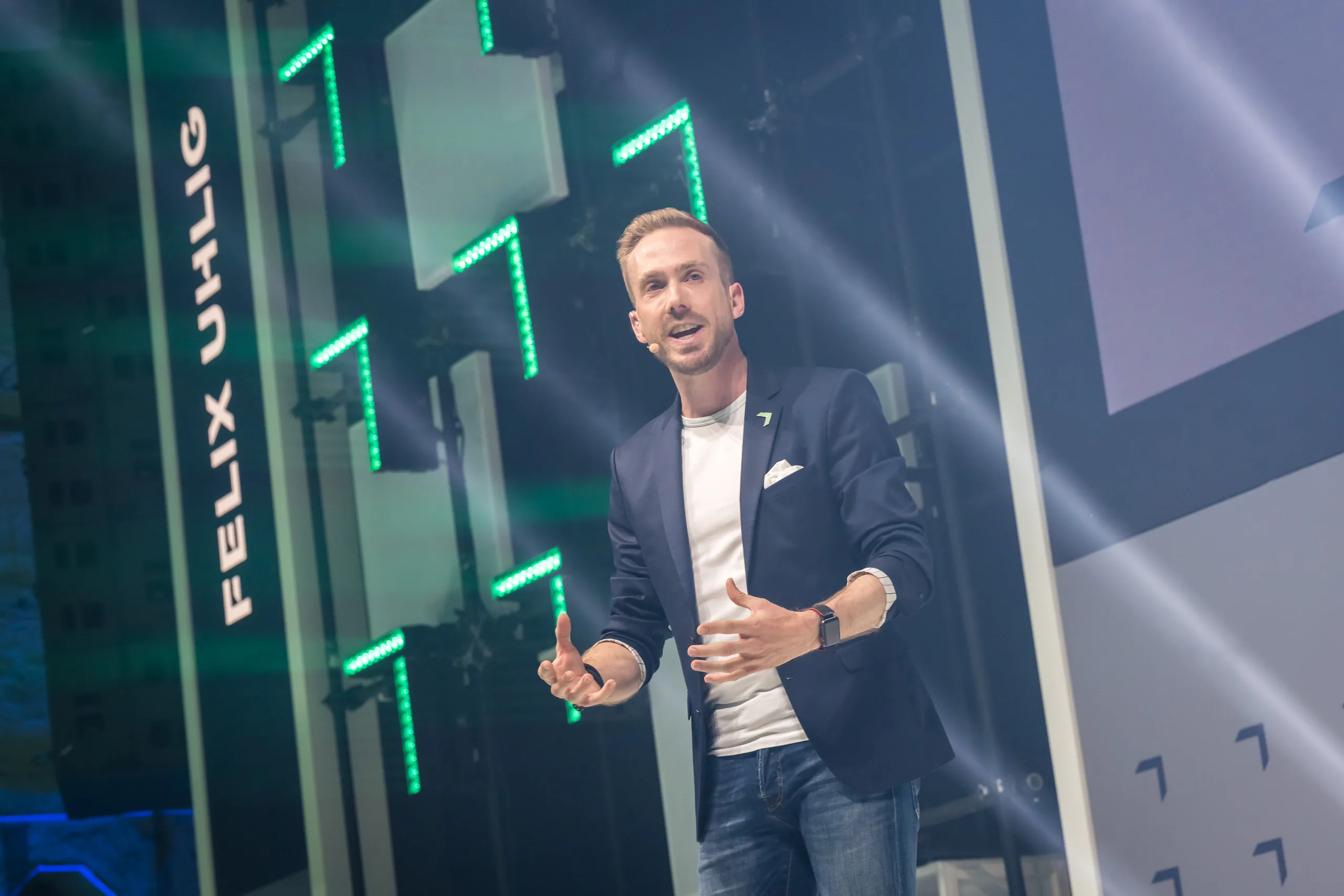 Felix Uhlig auf der Hauptbühne des Greentech Festival 2021, sein Name auf der LED-Wand dahinter