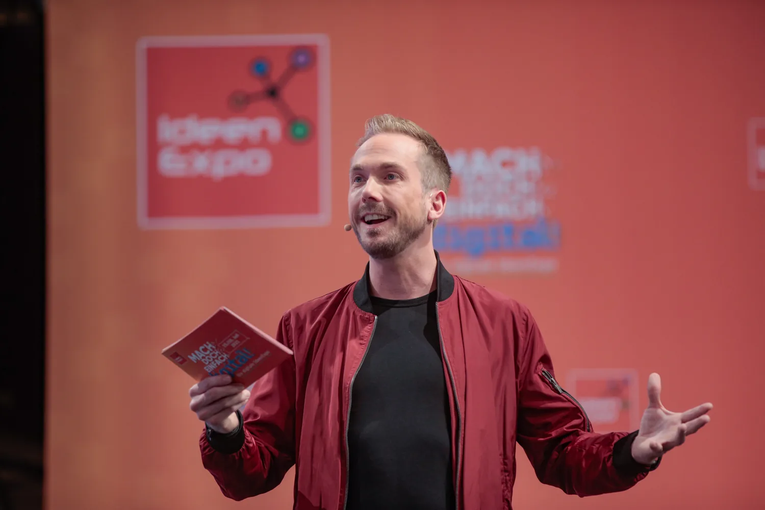 Host Felix Uhlig holding his notes on the main stage of IdeenExpo 2021 in Hannover