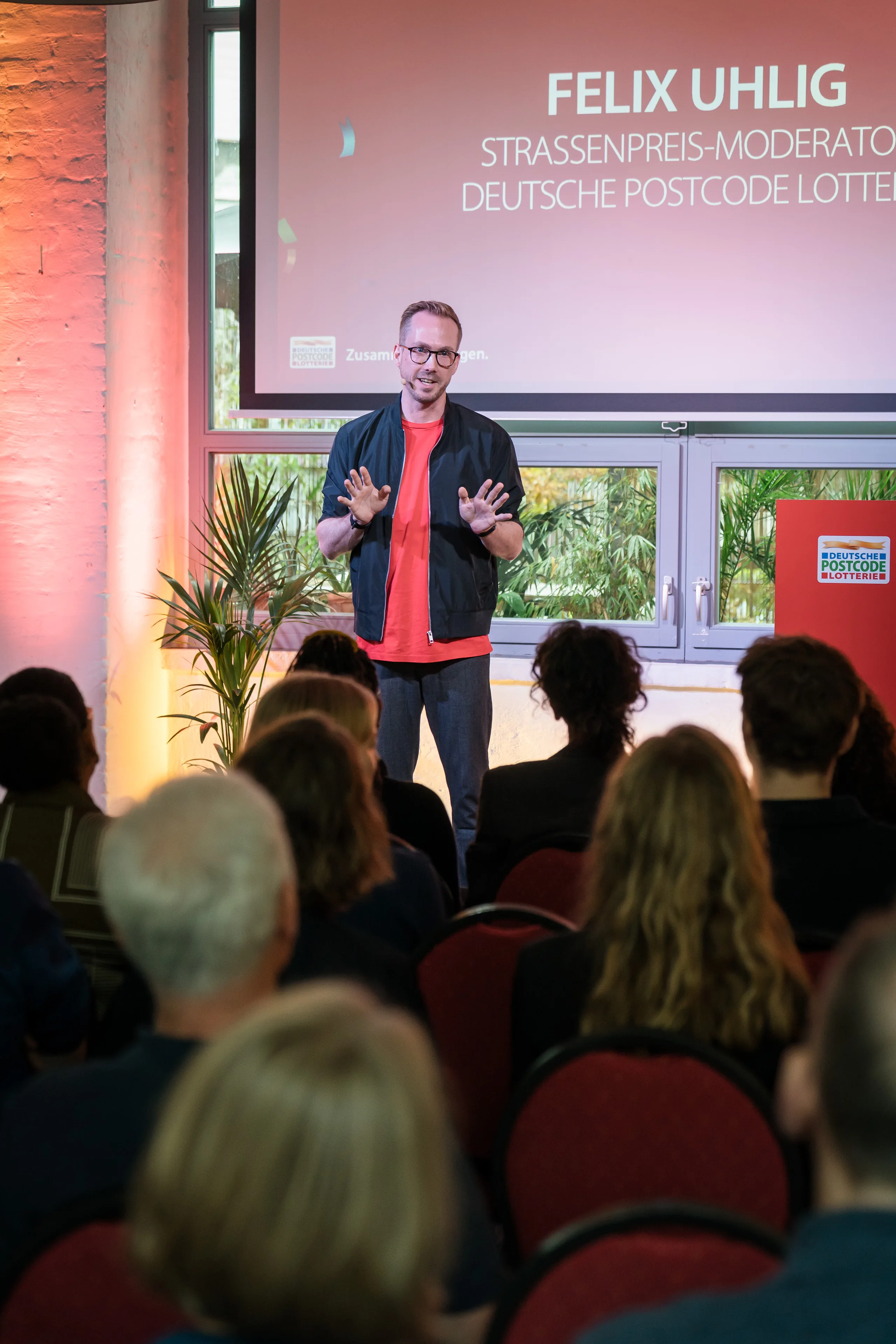 Event host Felix Uhlig on stage at the 2025 partner meeting of the Deutsche Postcode Lotterie in Berlin