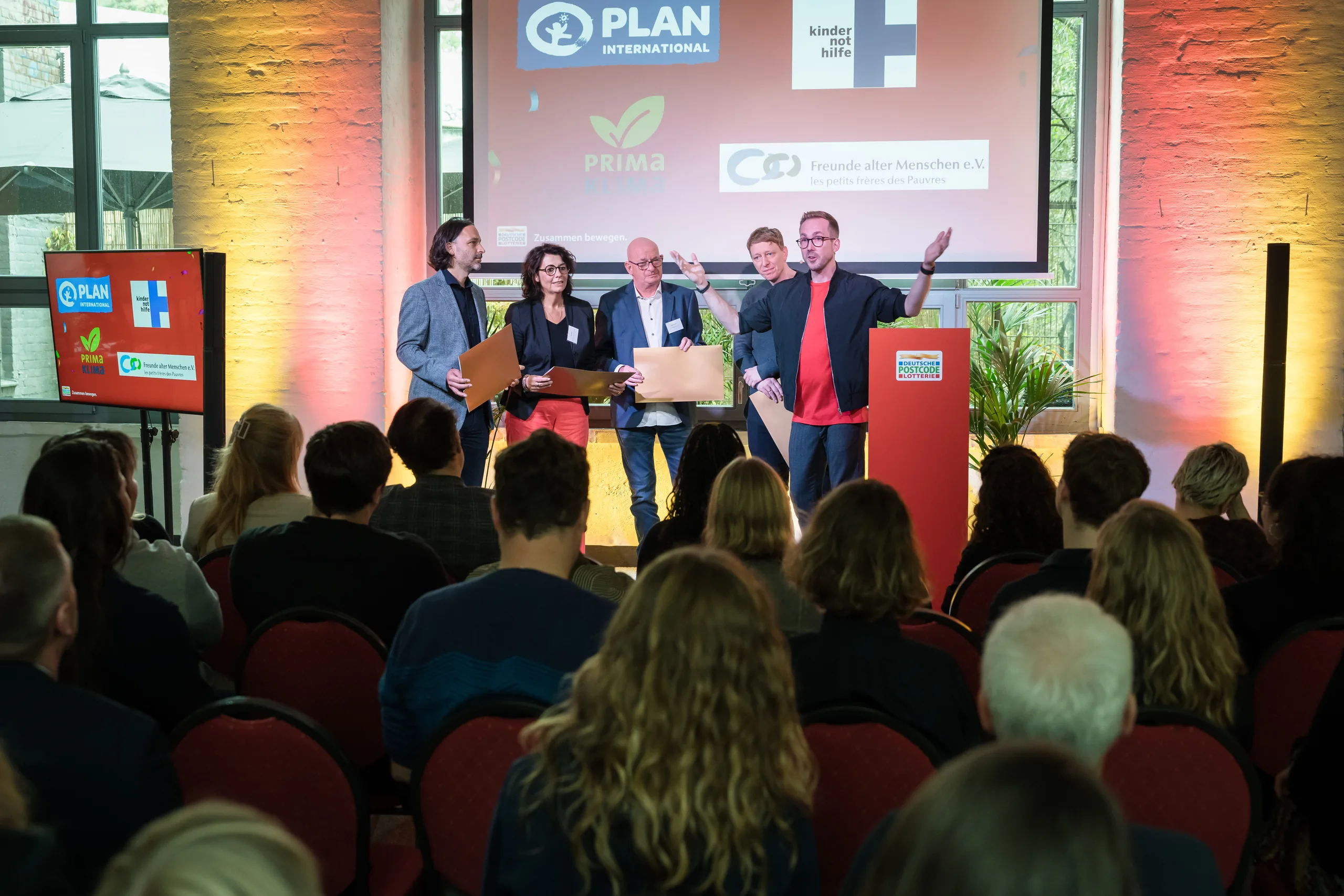Podiumsrunde beim Postcode Partner Treffen 2025 in Berlin vor den Logos der Förderpartner