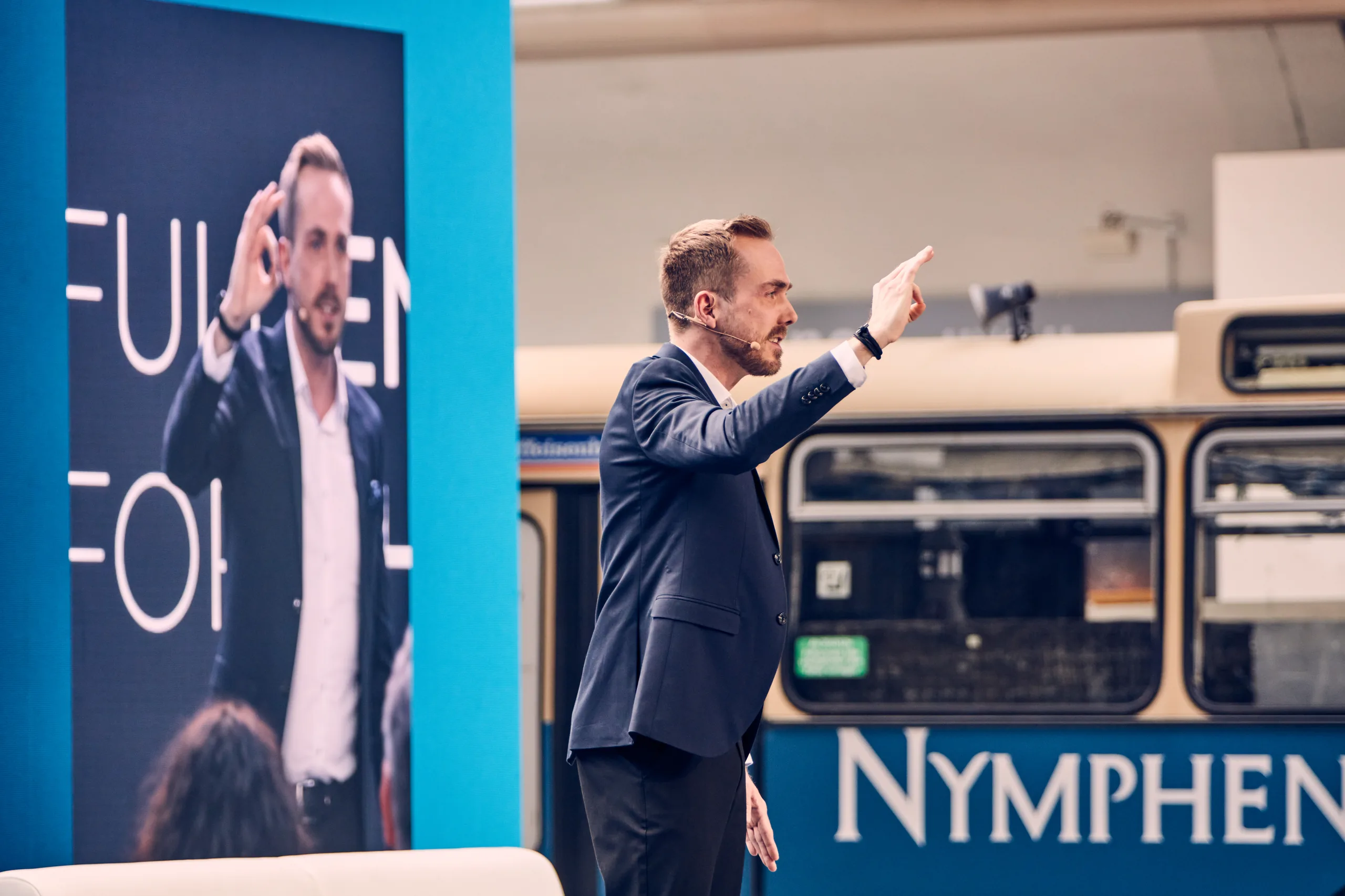 Felix Uhlig moderiert das Sonnen Partnerevent 2023 in München und weist ins Publikum