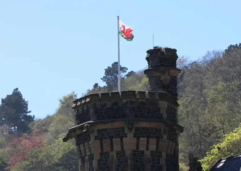 Die walisische Flagge über einem Turm in Wales