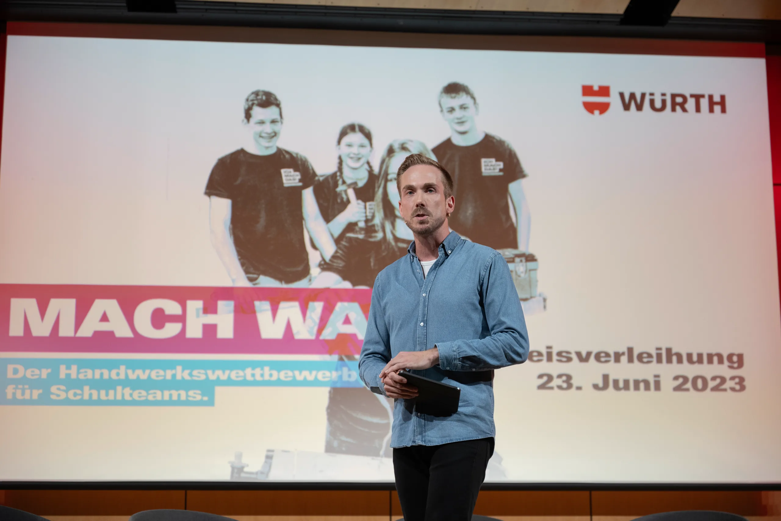 Felix Uhlig vor der Leinwand der MACH WAS! Preisverleihung von Würth am 23. Juni 2023 in Künzelsau