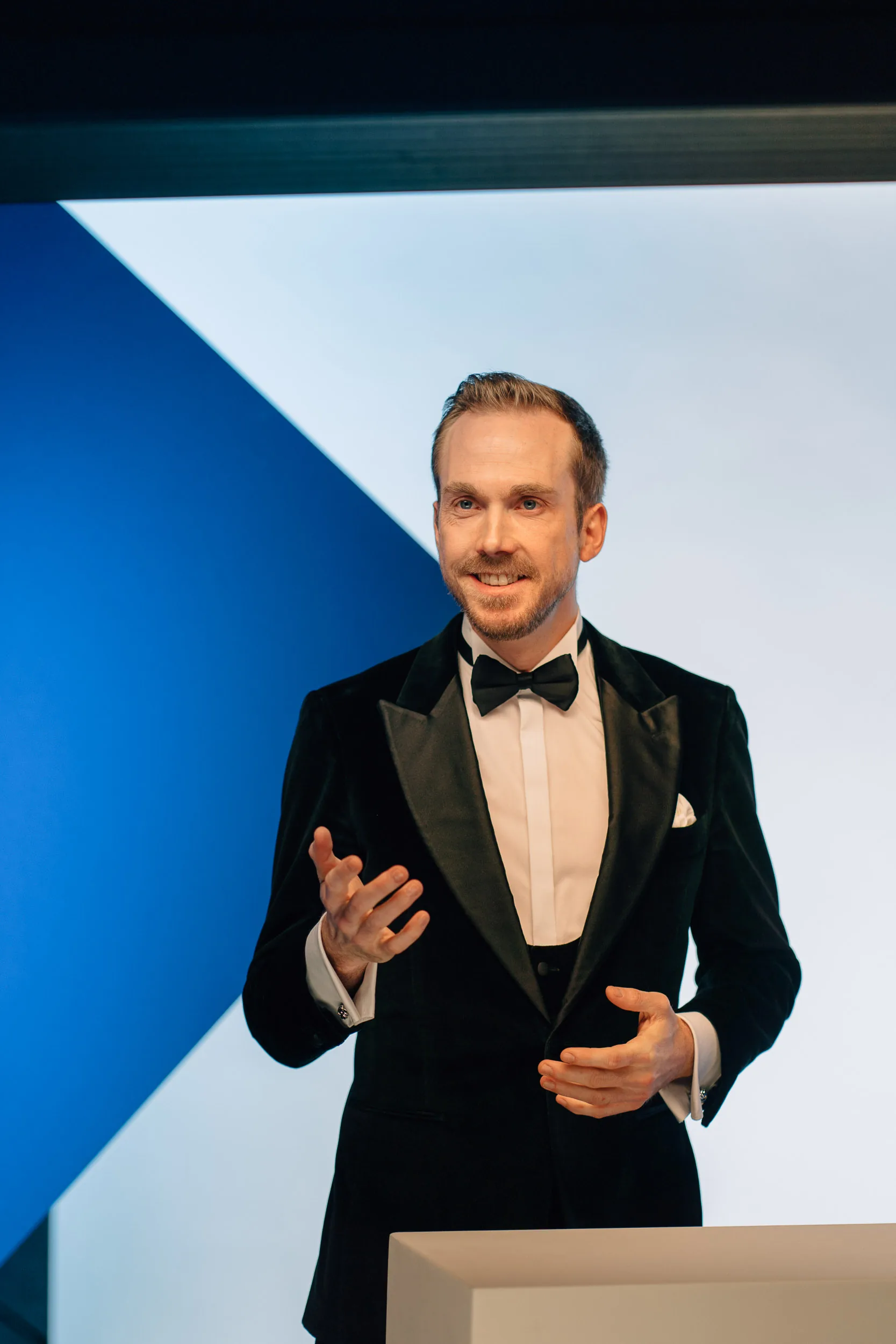 Moderator Felix Uhlig im Smoking vor der Kamera beim Ecolab Food Retail Service Award 2023