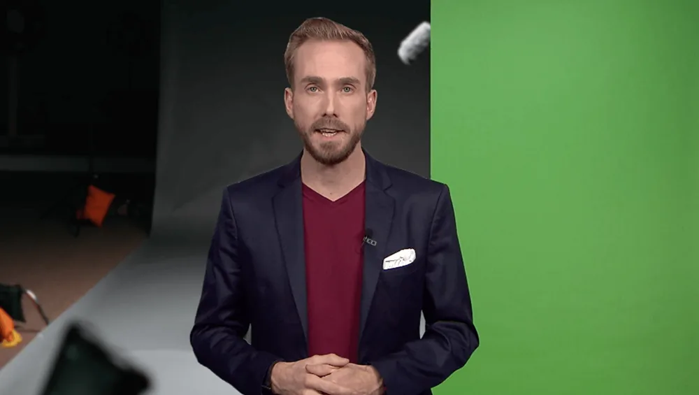 Online event host Felix Uhlig in his own home studio in front of a green screen and studio lighting